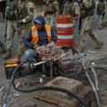 oldados marchan por Durán, Ecuador, mientras un trabajador repara cables de internet. Crédito: Associated Press